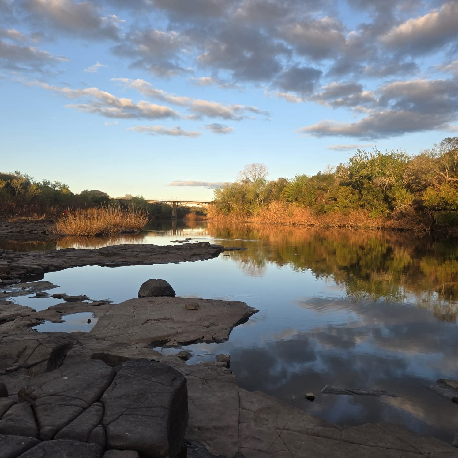 Cracked sandstone shelf and the bridge over the Río Daymán at Termas del Daymán, Salto, Uruguay