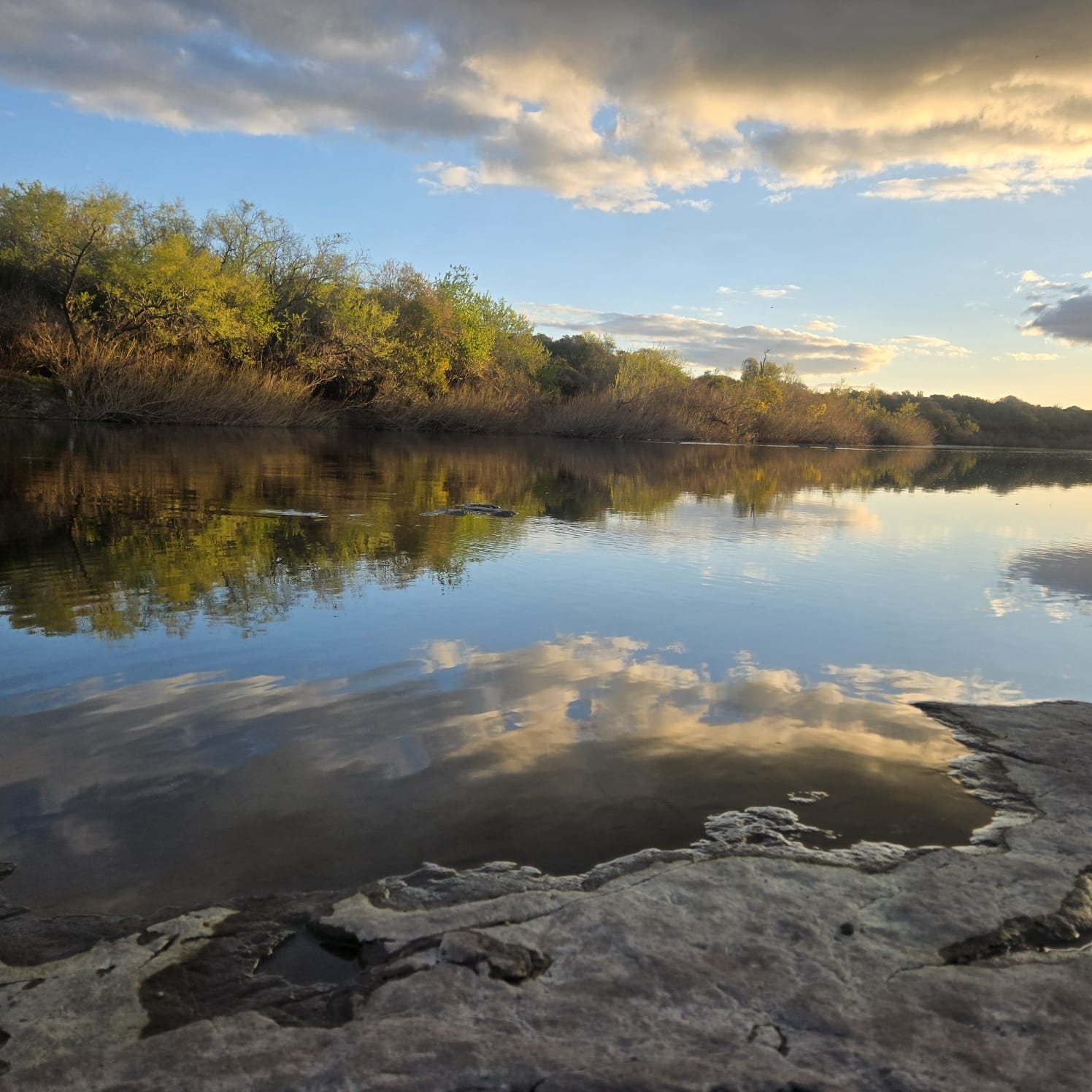 Flat rock shelf and cloud reflections on the Río Daymán at Termas del Daymán, Salto, Uruguay