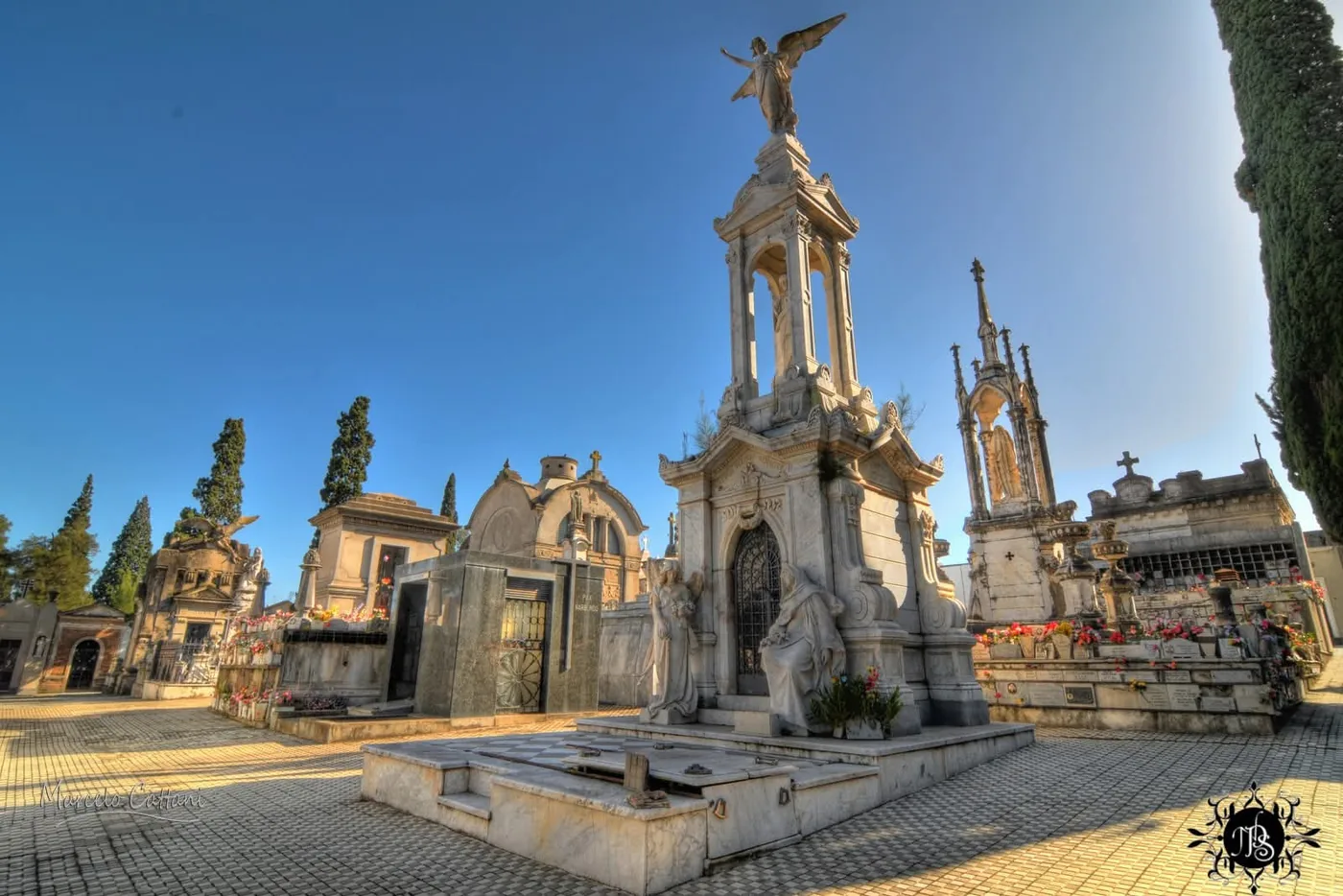 A tall Carrara-marble templete crowned by an angel, two female figures at its door, in the Central Cemetery of Salto, Uruguay