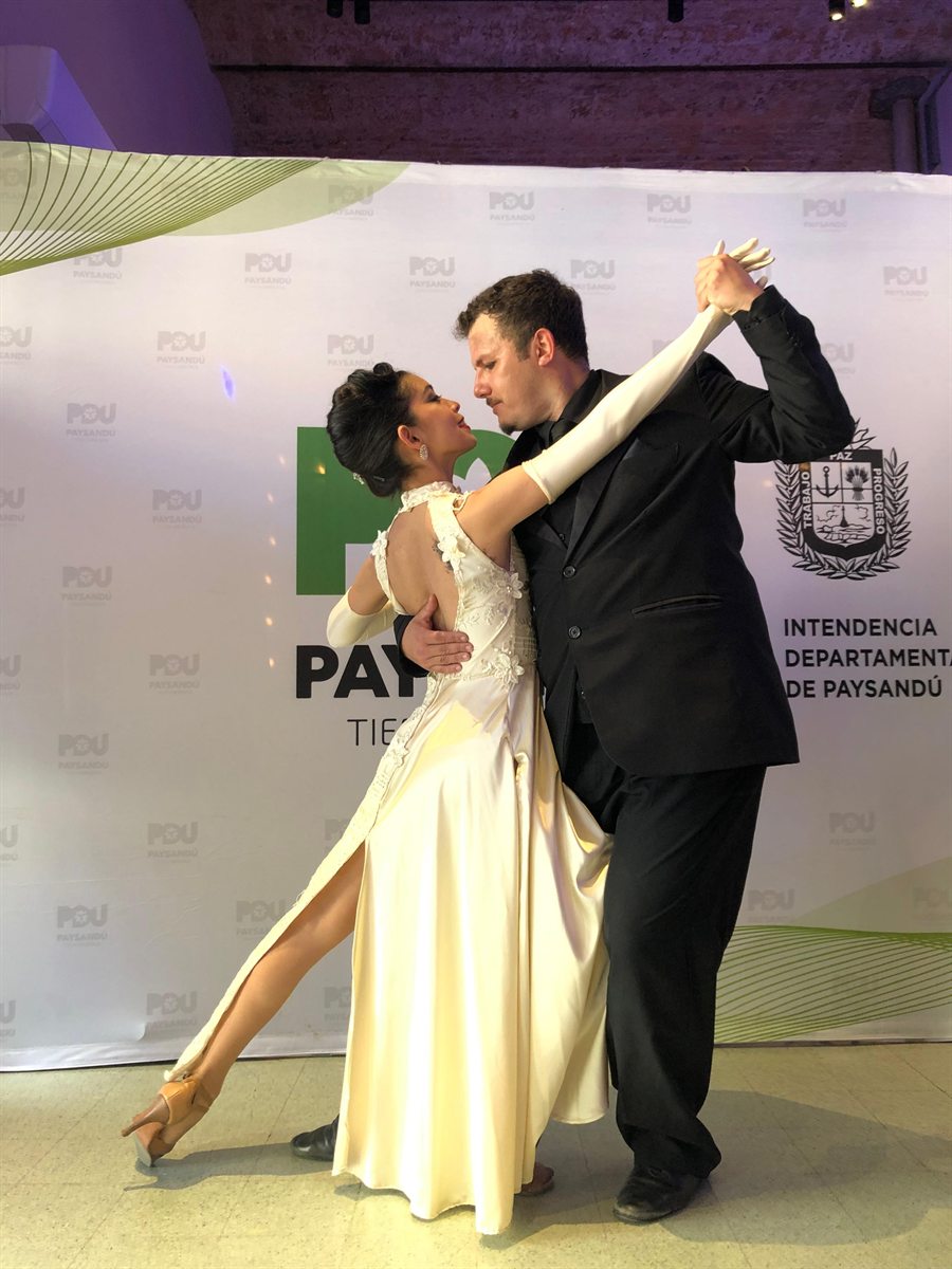Tango in Salto, Uruguay - tango dancer in a long ivory gown led through a turn by her partner