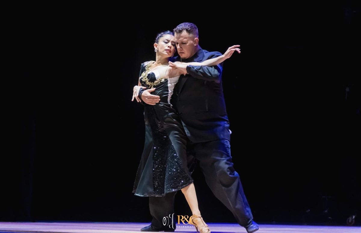 Tango in Salto, Uruguay - Angelina Diaz and Gary Etchegaray of AnGarTango in a close tango embrace under stage lights